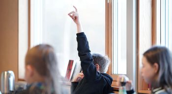 Gut som rekker opp handa i klasserom. Foto