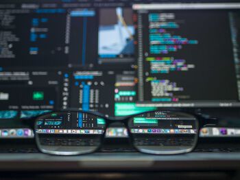 Glasses in front of a computer screen with numbers.