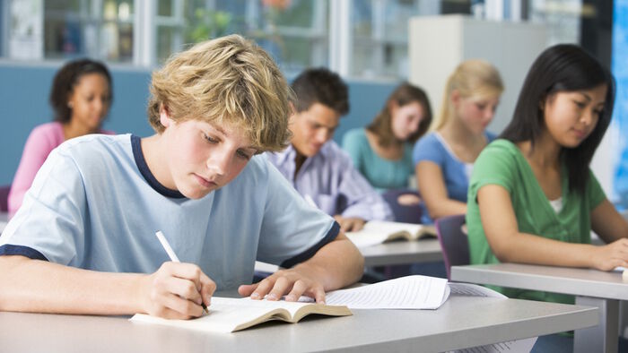 Elever sitter ved pultene sine i klasserommet. Illustasjonsfoto.