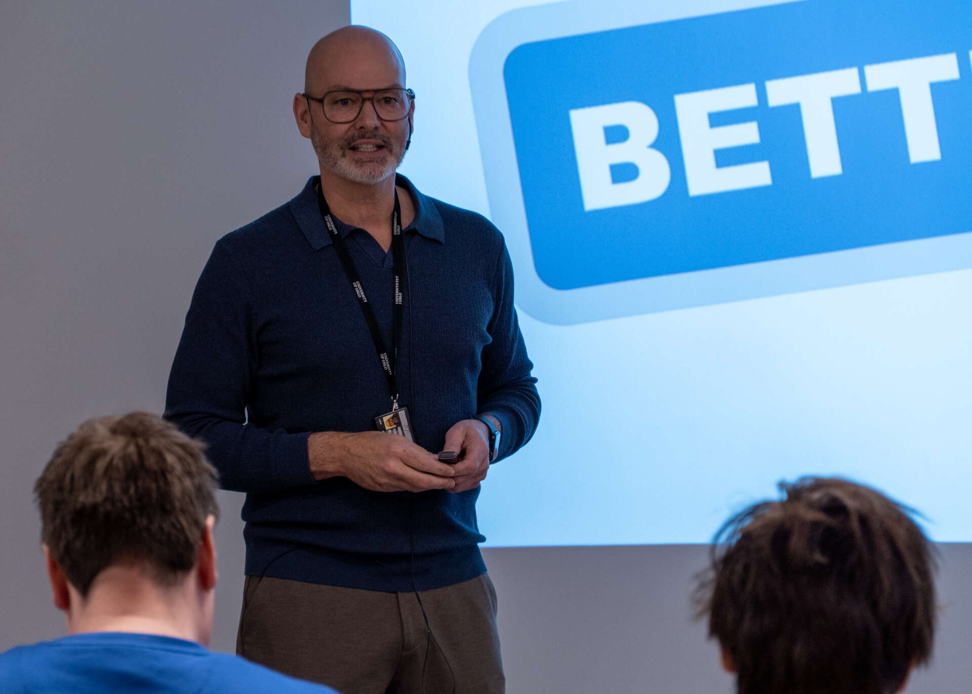 Man in front of a powerpoint presentation.