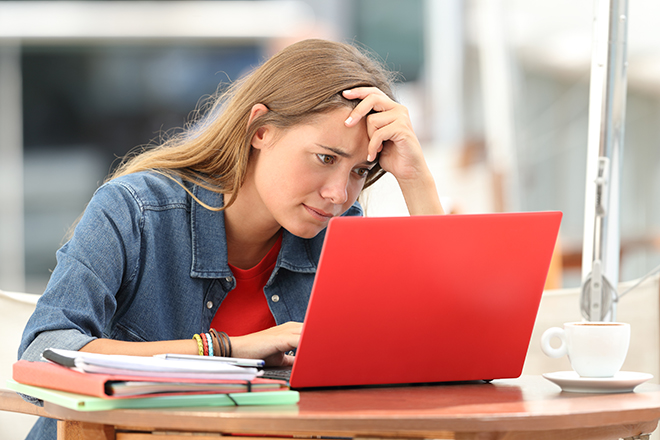 Kvinnelig student foran PCen, ser konsentrert ut