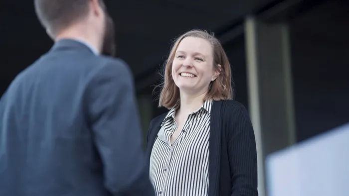 Bilde av en dame som smiler til en mann, voksne mennesker