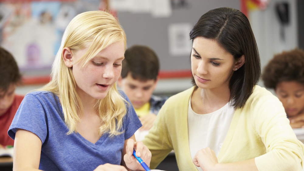 Photo of teacher helping student with reading assignments (photo: Colourbox).