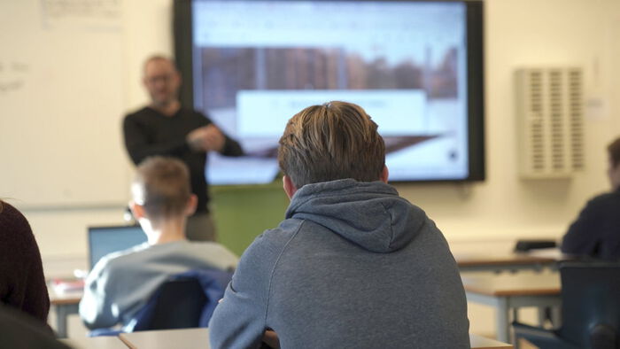 Elev med ryggen til ser mot tavla