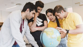 Students in front of globe. Illustration photo.