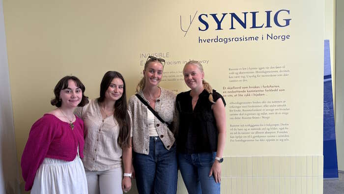 studenter foran et skilt der det står u synlig hverdagsrasisme i Norge