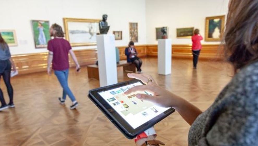 Dame med ipad på museum. Foto.