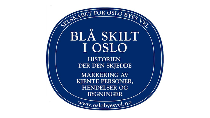 Bilde av blått skilt eller plakett. Oslo Byes Vels historiske skilt over personer. Det står: Selskabet for Oslo Byes Vel. Blå skilt i Oslo. Historien der den skjedd. markering av kjente personer, hendelser og bygninger.