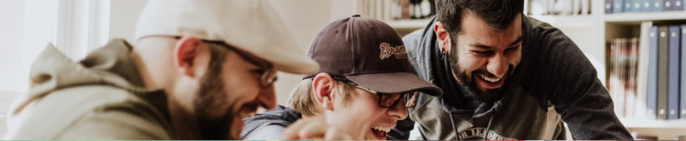 Tre studenter smiler og ler