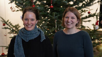 Smilende Joke Dewilde og Astrid Marie Jorde Sandsør ved et juletre. Foto