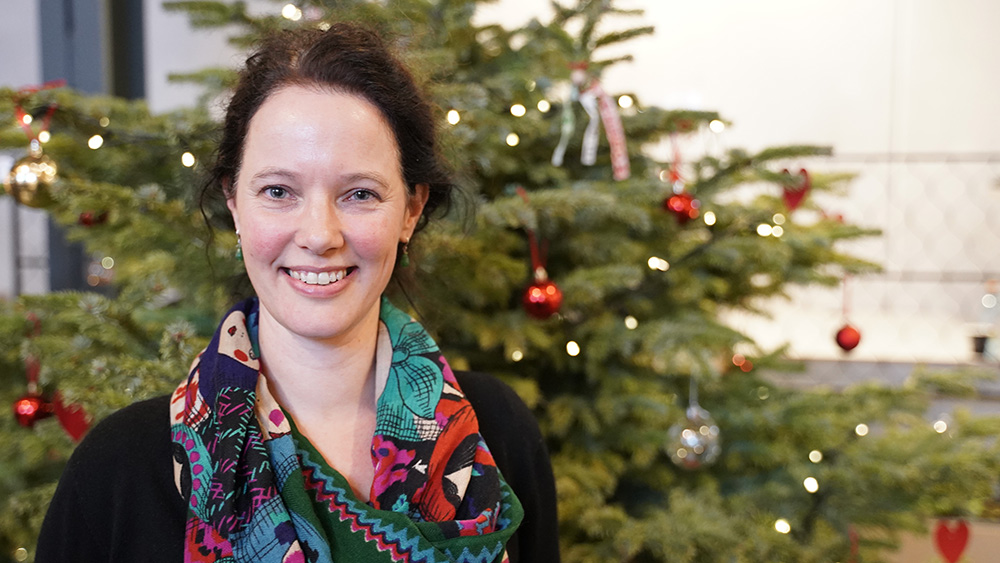 Joke Dewilde står foran et juletre og smiler