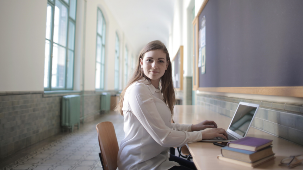 Kvinnelig student som studerer på datamaskinen