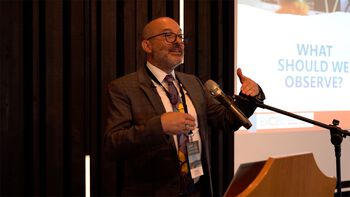 Glasses ,Microphone ,Podium ,Public address system ,Tie.