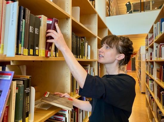 Ida Gabrielsen in the library browsing books