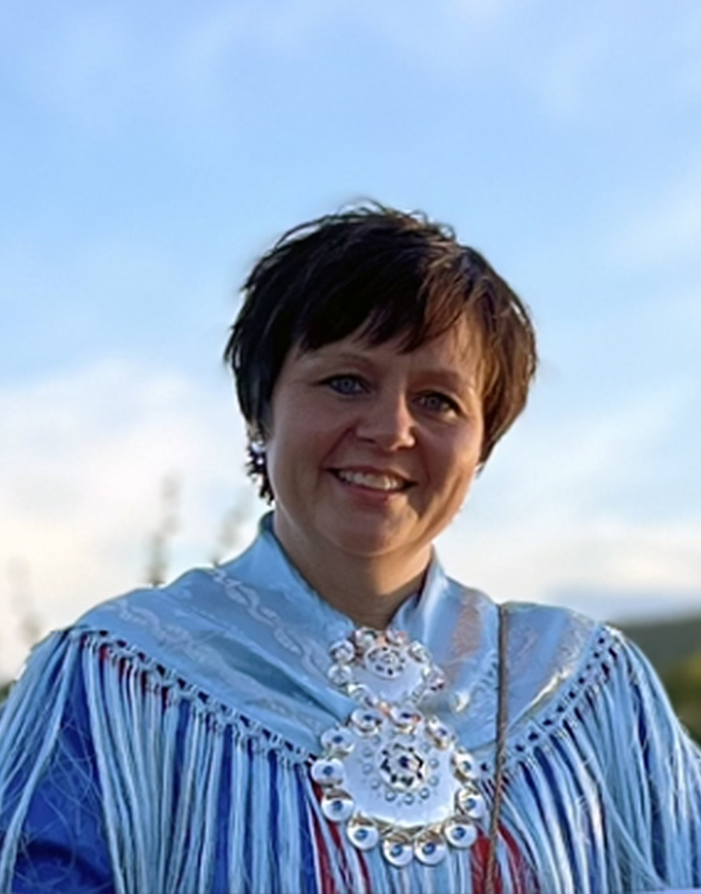 Bildet kan inneholde: person, ansikt, smil, himmel, erme.